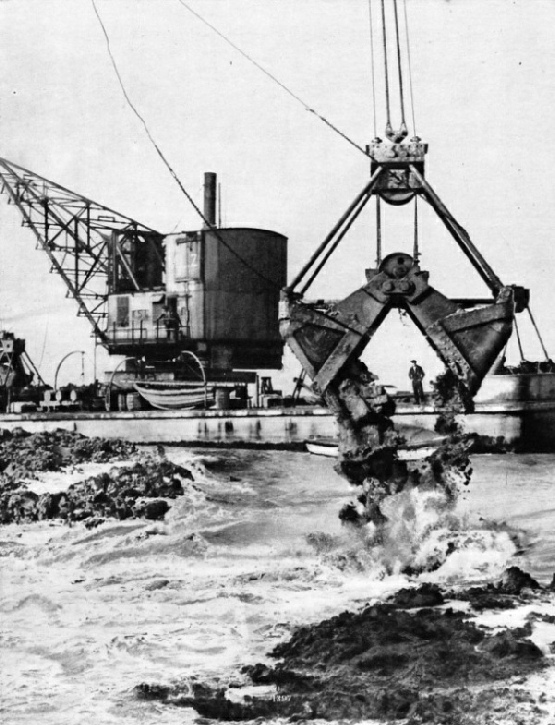 ENORMOUS GRABS, operated by floating cranes, were used to build up the core of the dam