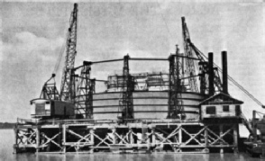 DISMANTLING one of the steel shells used in the construction of the main piers of the Huey Long Bridge