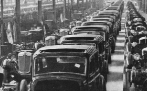 COMPLETED AND TRIMMED motor car bodies are brought alongside the finished chassis by a conveyer preparatory to fitting