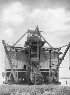 THE ENDLESS CHAIN OF BUCKETS in a modern tin mine dredge