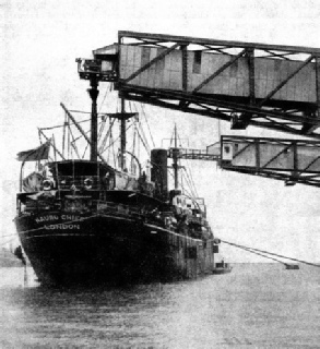 TELESCOPIC DELIVERY SPOUTS lead from the conveyer belt into the holds of the Nauru Chief