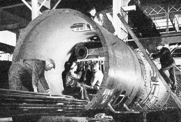 ERECTING THE SUPERHEATER in the boiler of a mammoth American freight locomotive