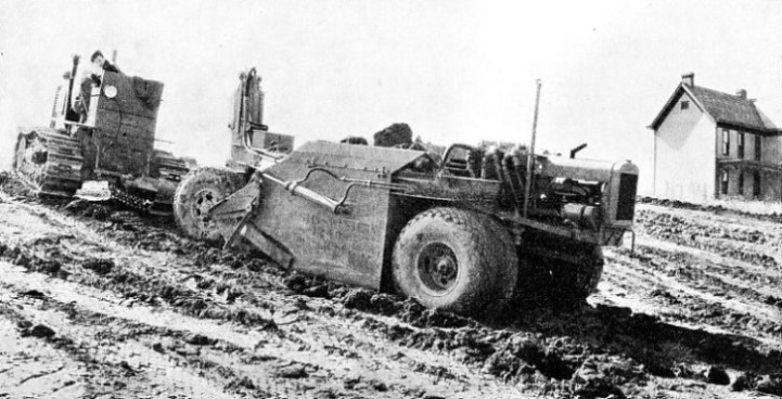 SCRAPER AT WORK removing the top soil, the first stage of road construction