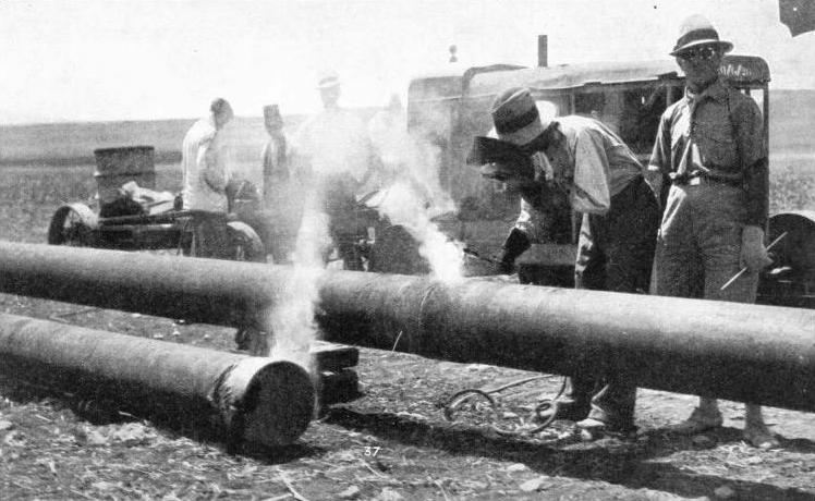 WELDERS AT WORK joining two of the pipes