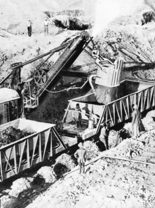 Steam shovels load copper ore into railway trucks